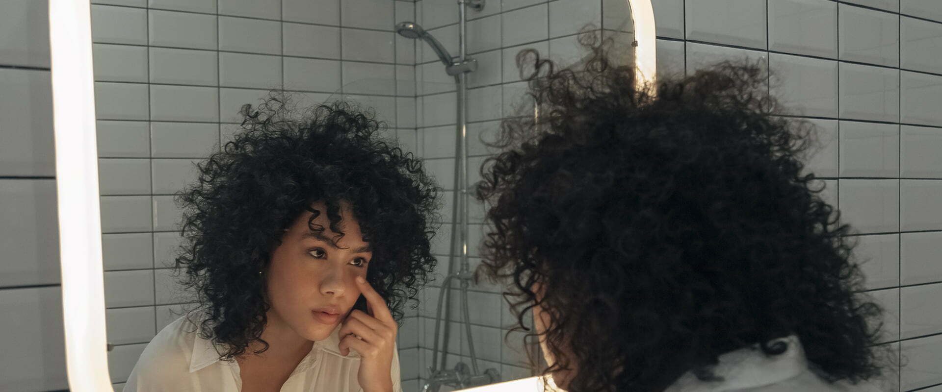 woman looking at herself in the mirror